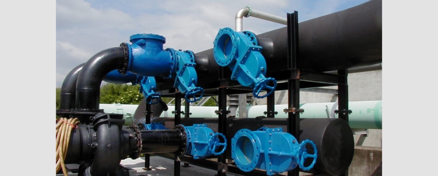 Blue flanged gate valves and 600mm bore black pipework on a steel support frame
